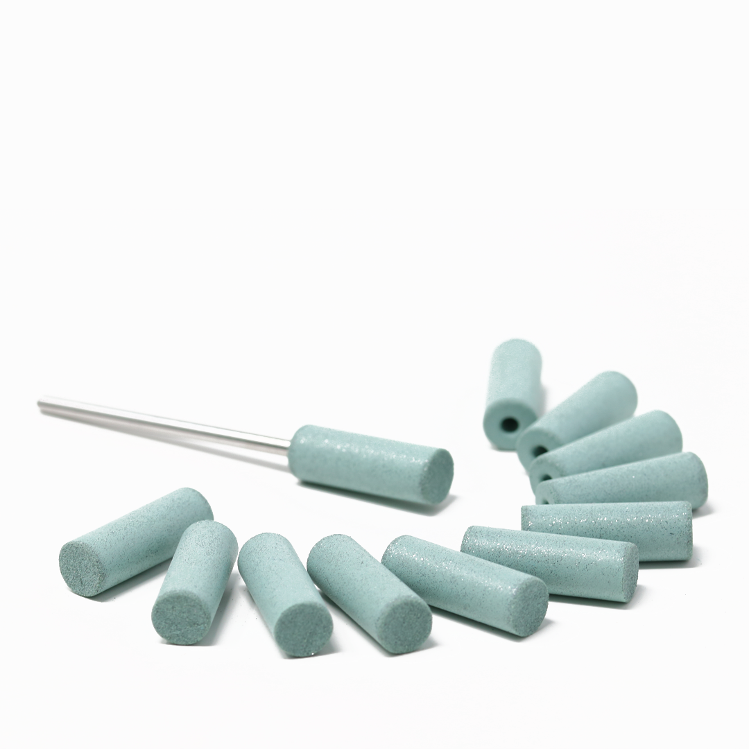 Set of twelve blue polishing cylinders on a white background; one has a mandrel attached.