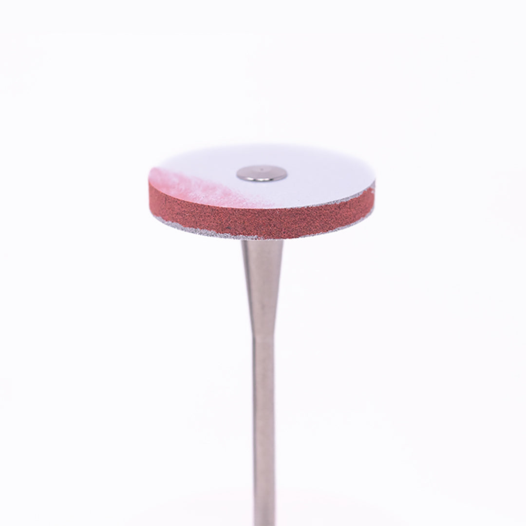 An anax Rotary red-and-white disc-shaped wheel bur for dental use on a white background.
