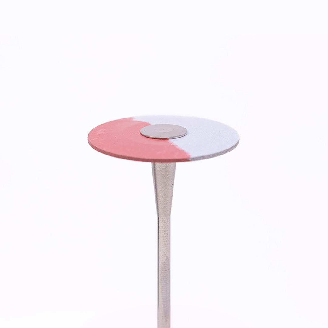 An anax Rotary red-and-white disc-shaped wheel bur for dental use on a white background.