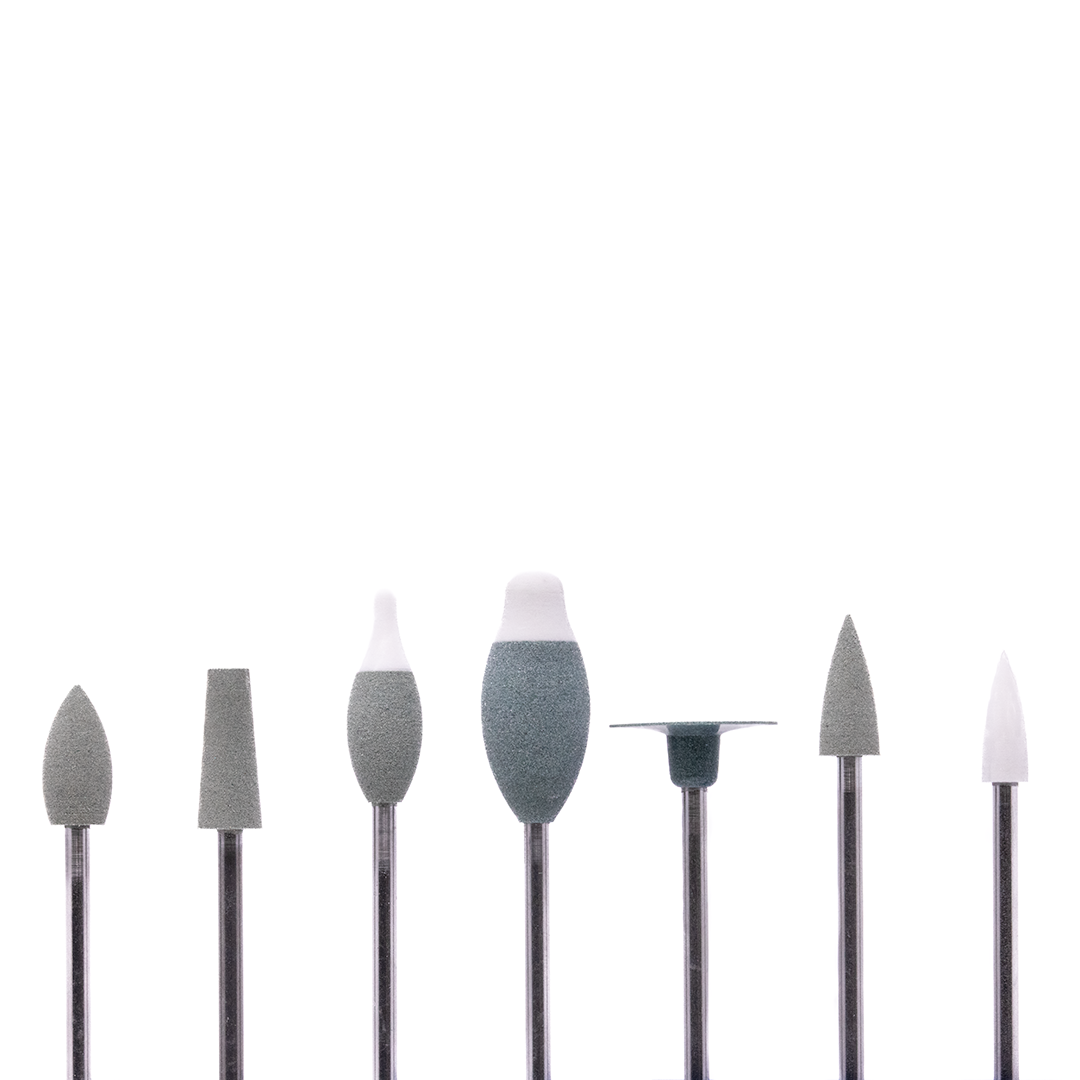 A set of 7 different rotary burs arranged in a line on a white background.