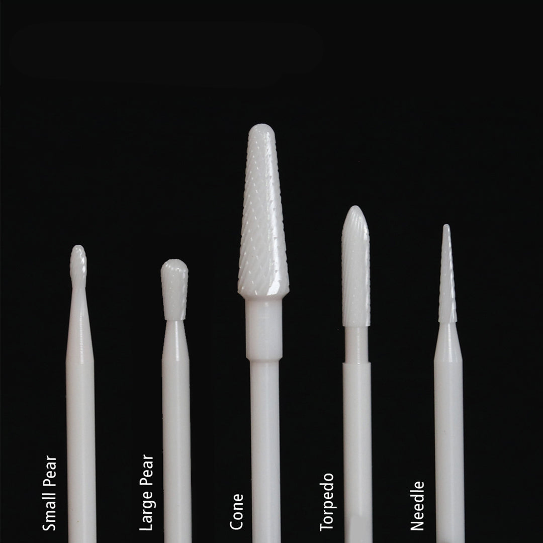 Set of 5 white rotary burs, each with a different tip, on a black background.