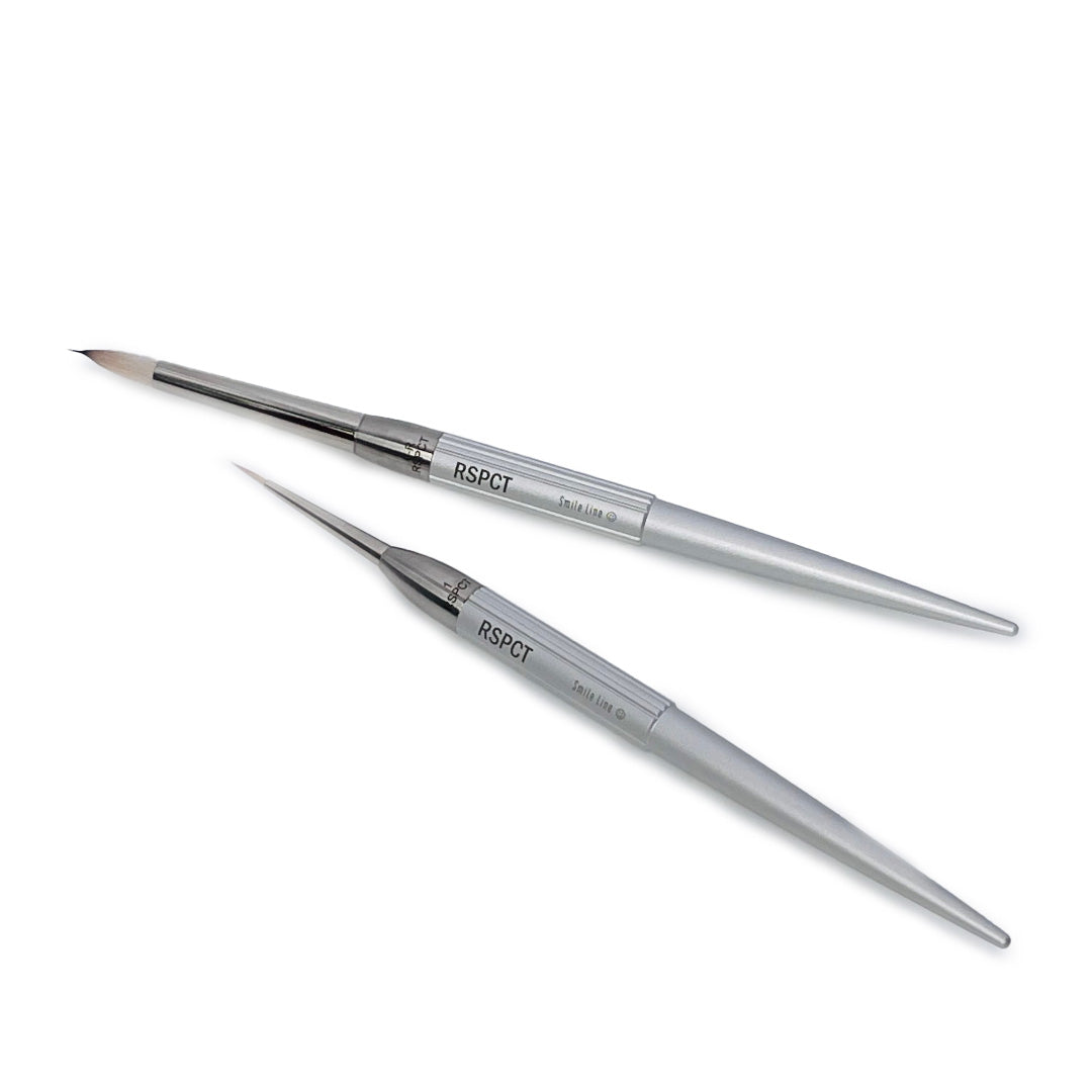 One Smile Line RSPCT Brush #6 and one Smile Line RSPCT Brush #1 next to each other at an angle on a grey background.