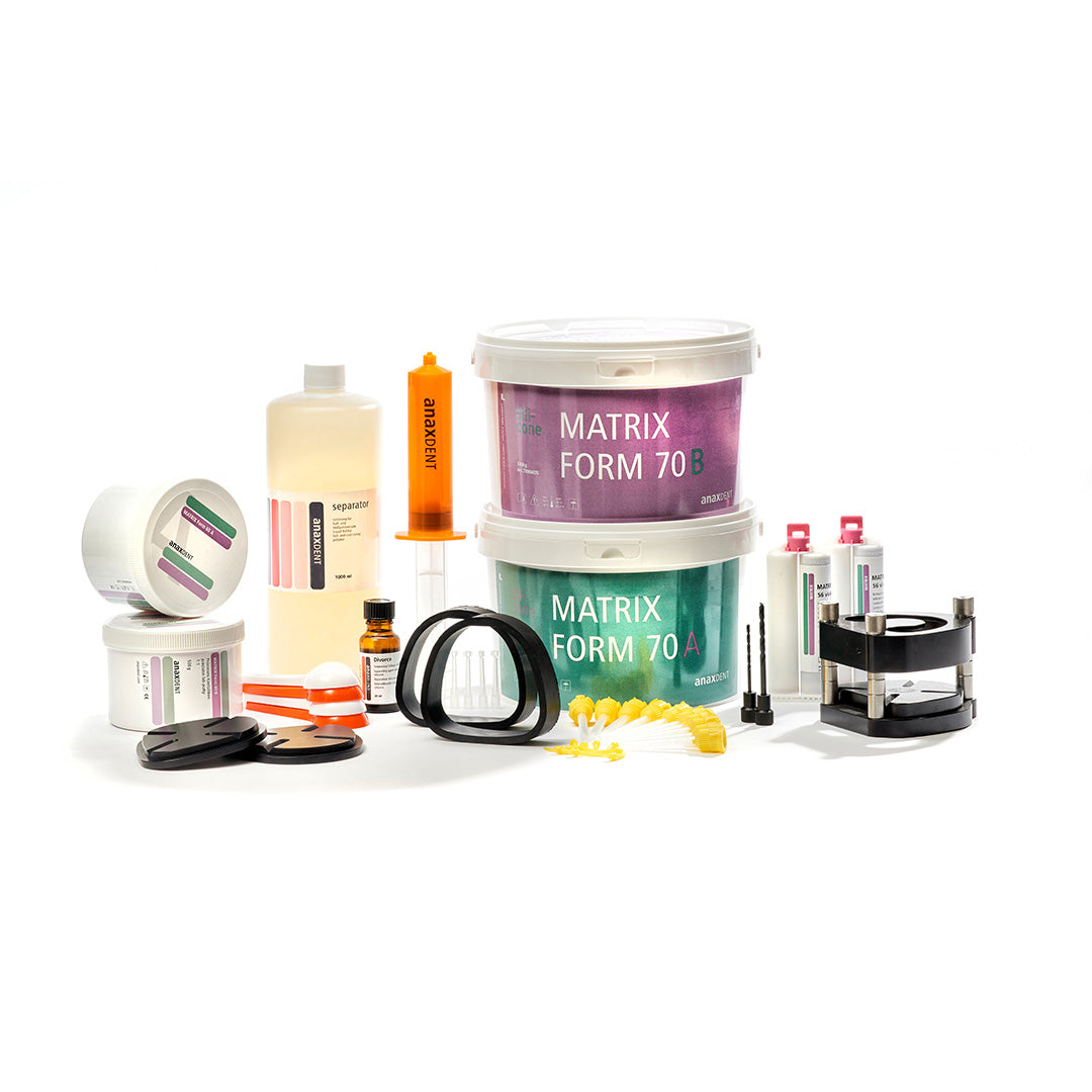 A collection of dental laboratory equipment and supplies, including molds, tips, scoops putty containers, and other materials, arranged on a white background.